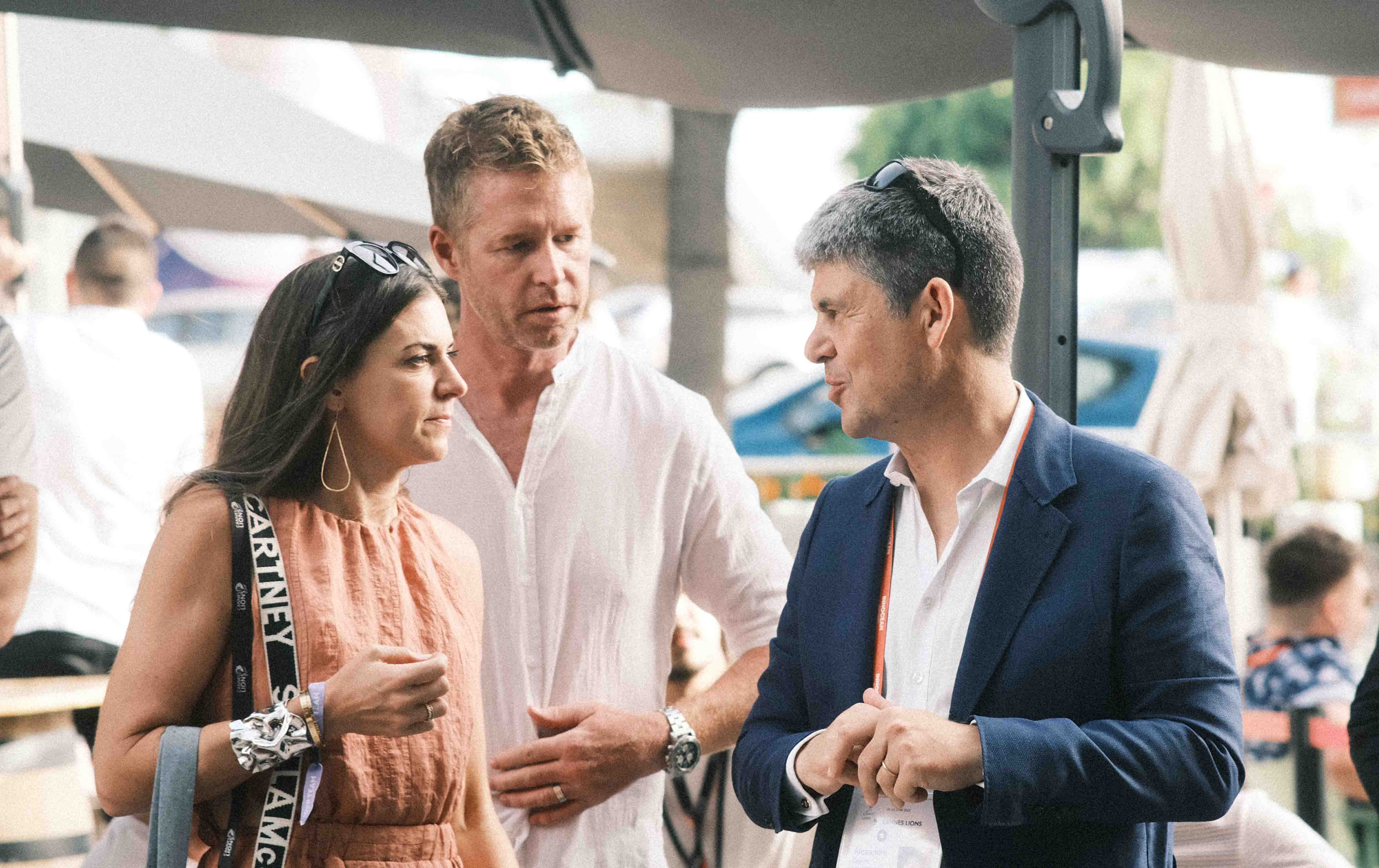 Three employees chat together at Cannes meet-up