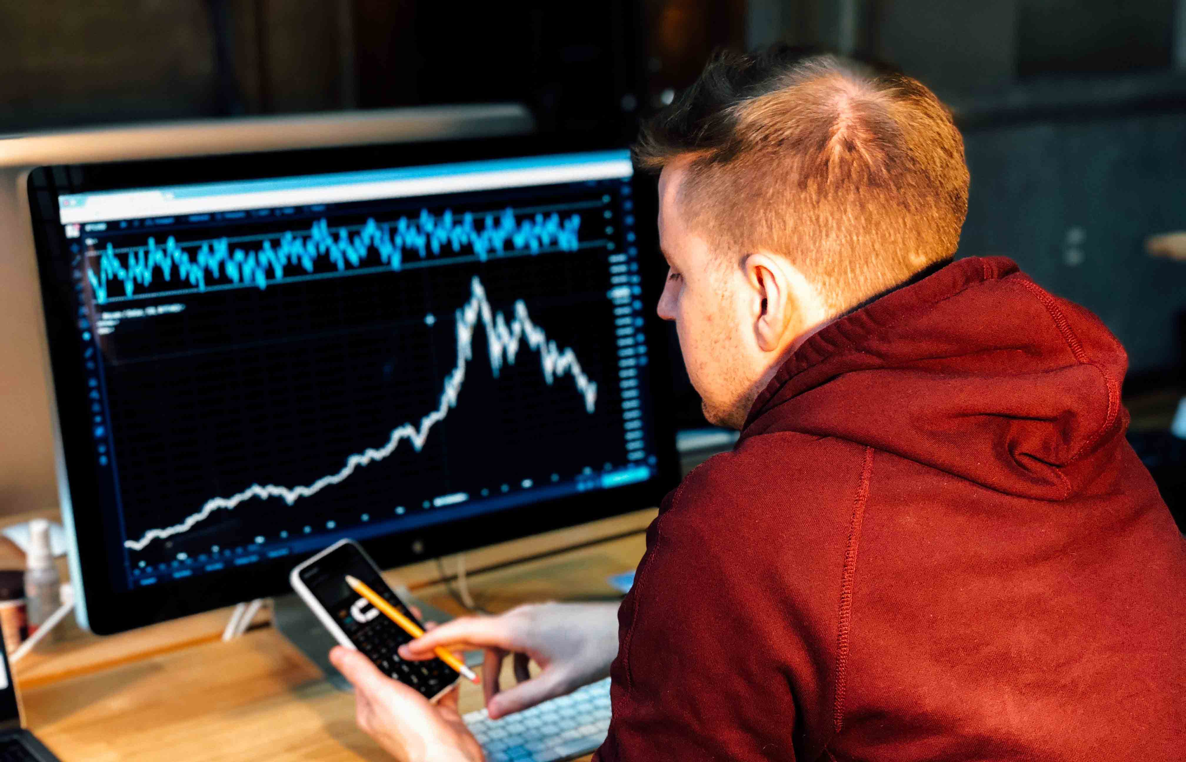 A person staring at an analytics dashboard on a computer and phone
