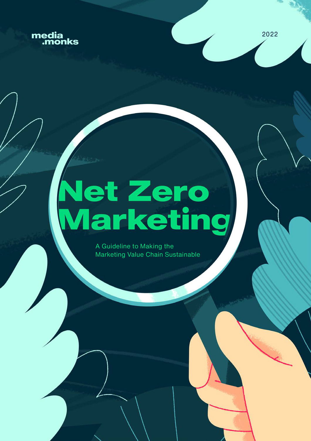 illustration of a hand holding a magnifying glass, encircling the words "Net Zero Marketing", with leaves framing the illustration