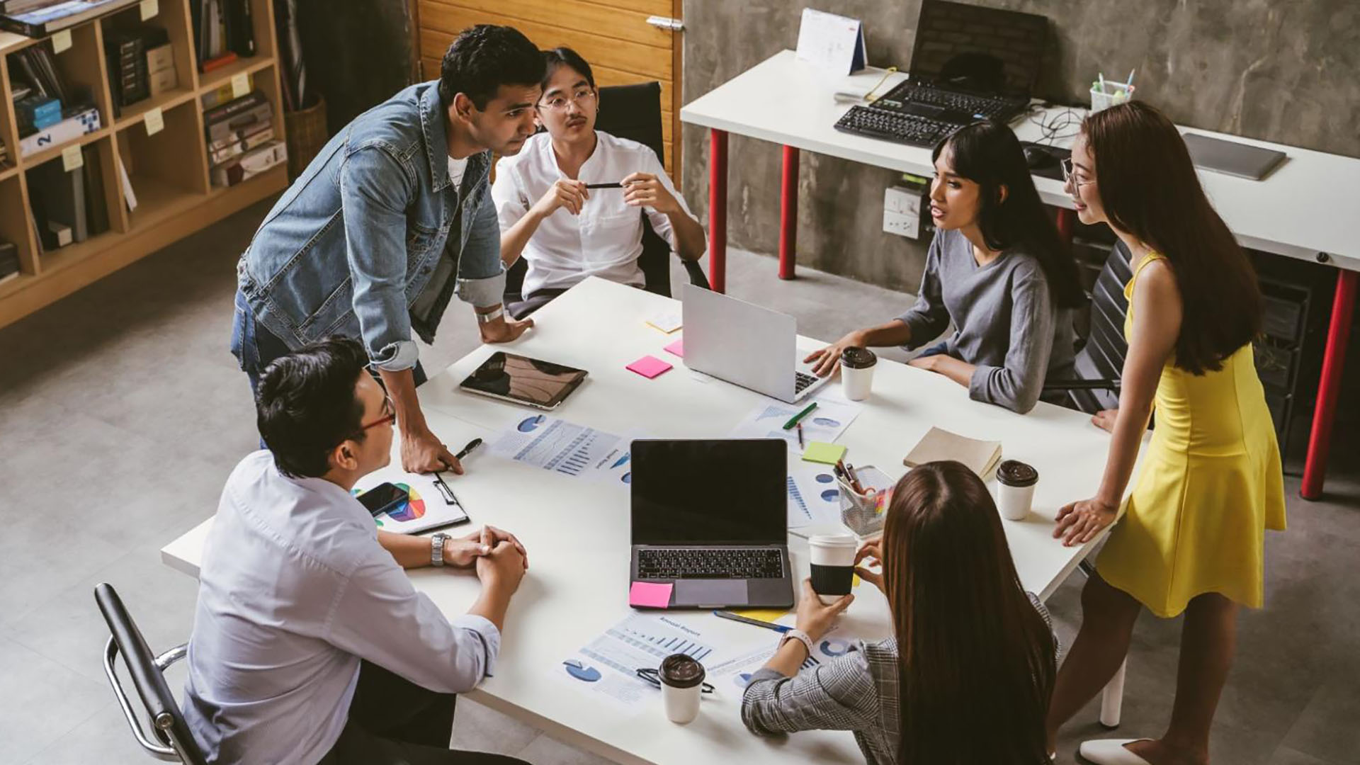 Employees standing over a table working together
