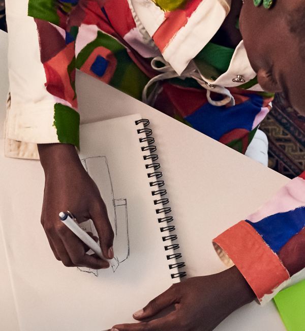 A woman drawing in her notebook with a uni pen