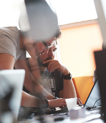 Two employees working on a desktop together
