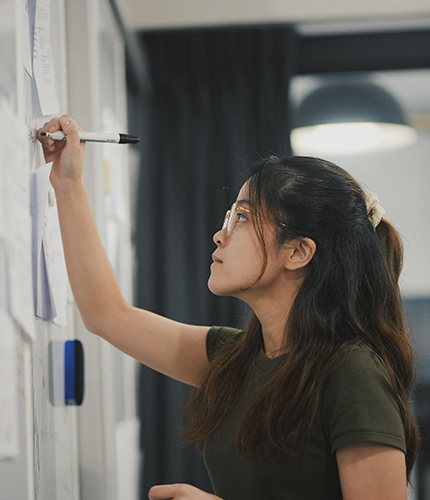 A woman working on a whiteboard