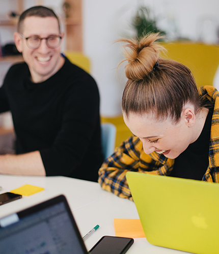 Two employees laughing while working together