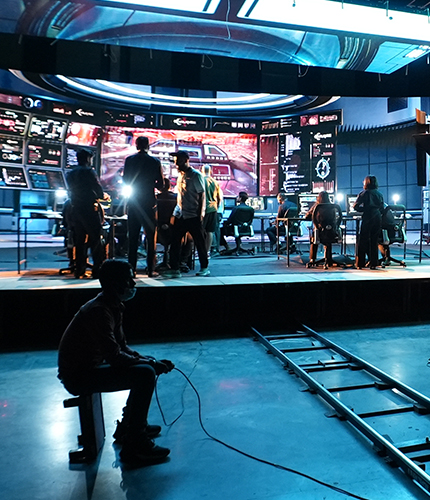 A studio with cameras filming someone at a desk