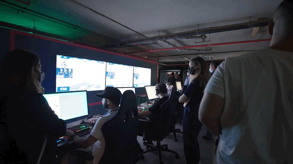 people gathered around screens playing valorant