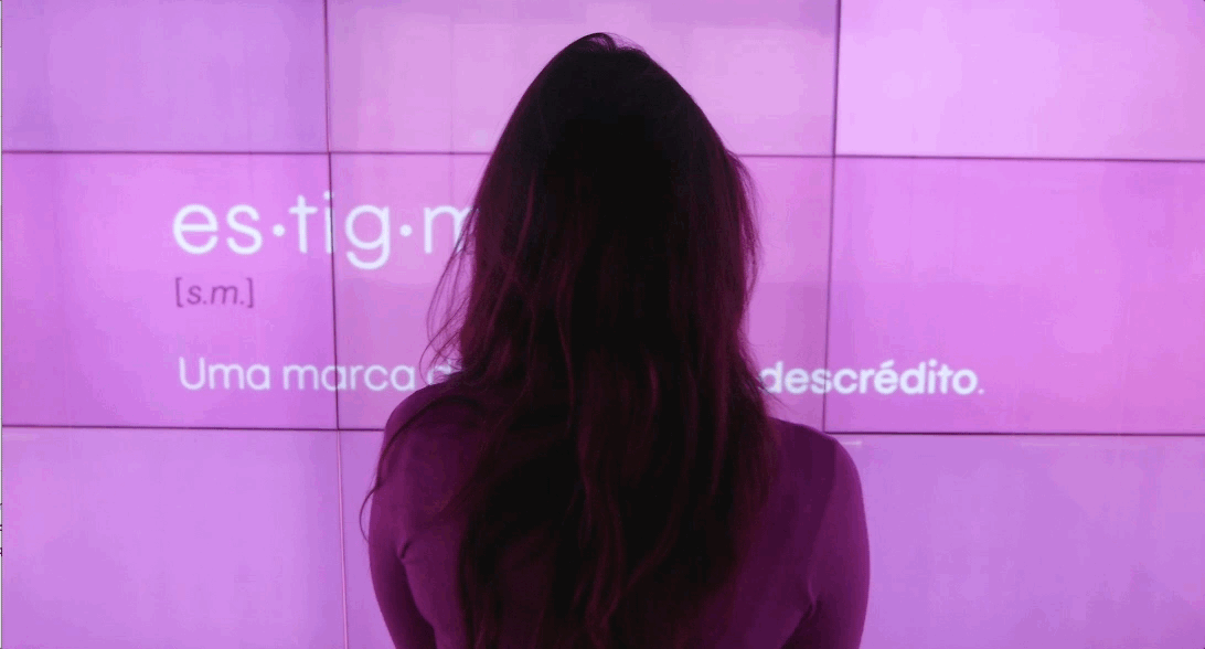 A person standing in front of a large amount of LED screens