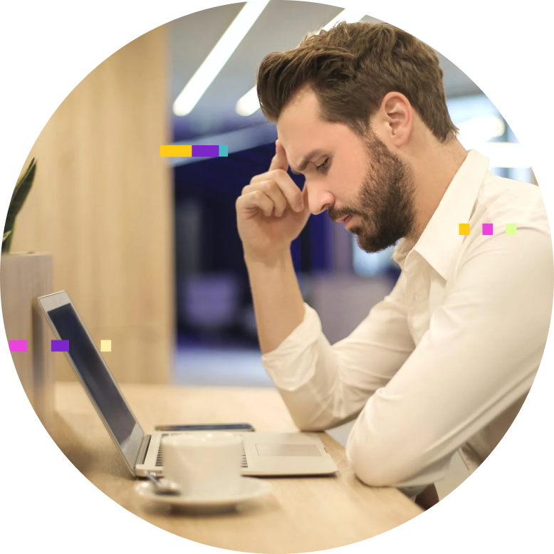 A person sitting at a desk working on a laptop enjoying a cup of coffee