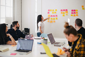 A group of employees working in a conference room and at a whiteboard