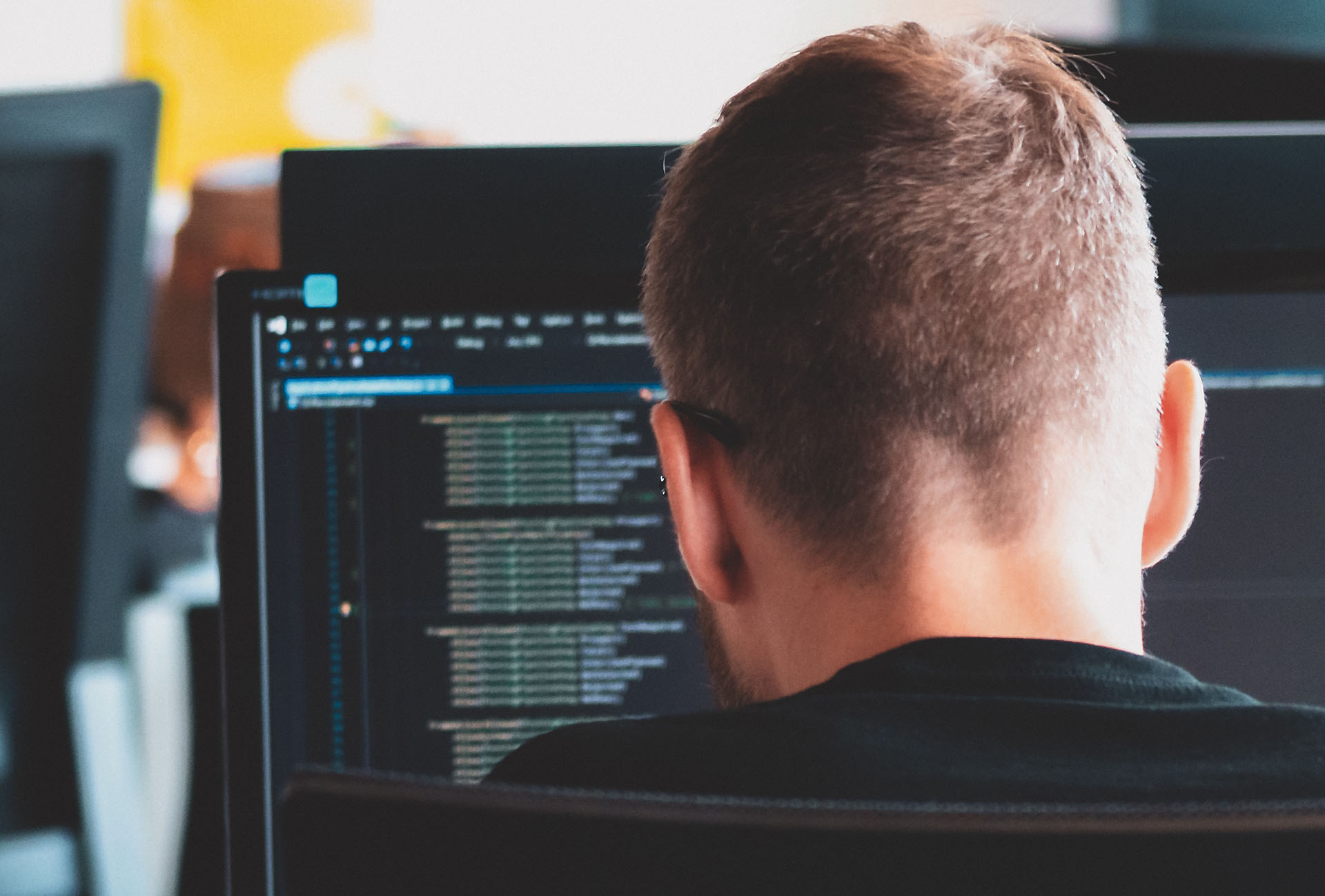 A person overlooking code lines on a computer