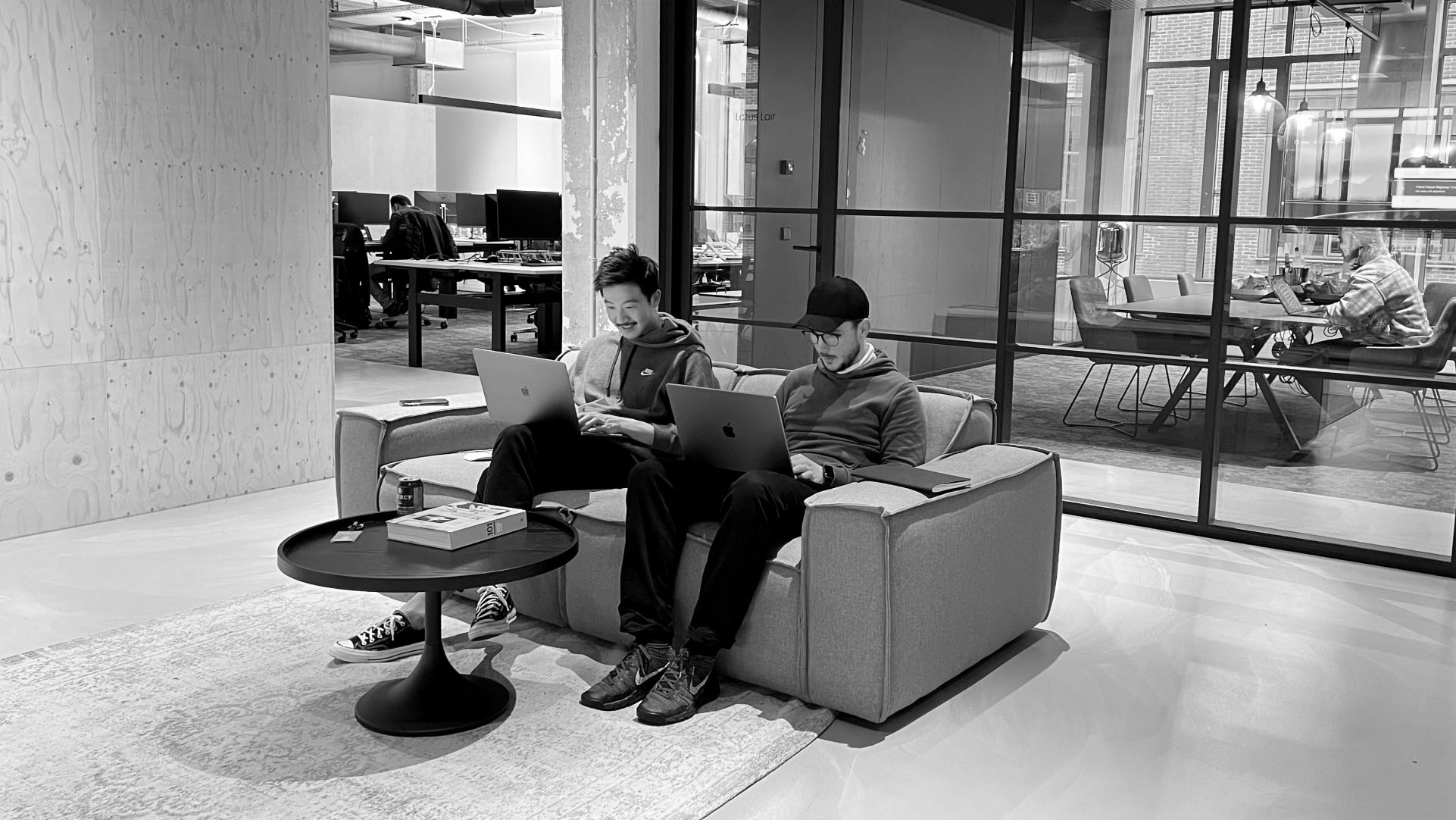 Two media.monks employees sitting on a couch working together