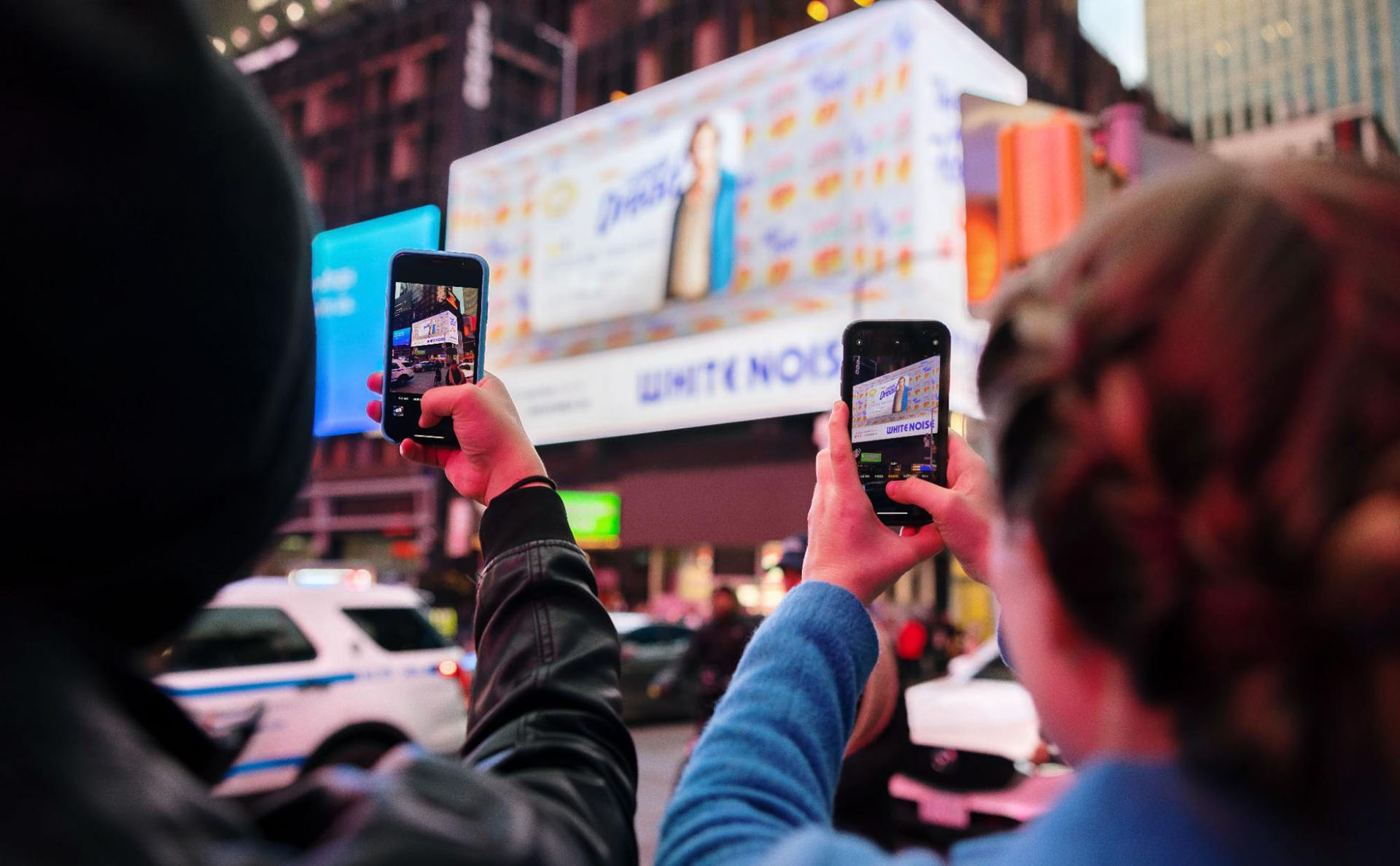 People taking photos on their phone of a billboard