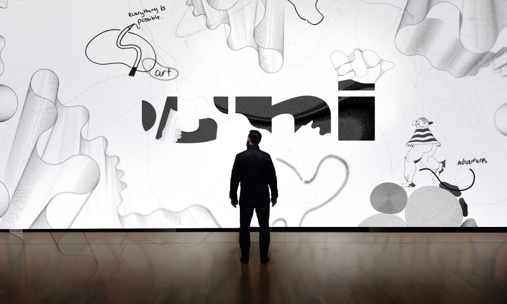 A person standing and looking up at a mural of uni designs