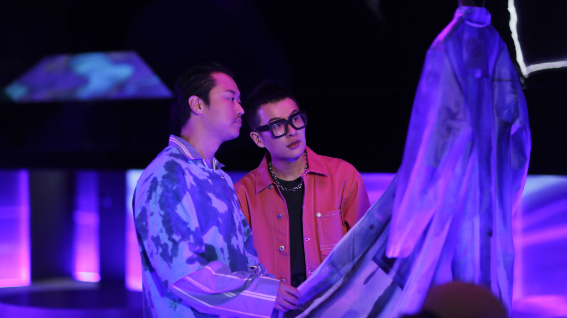 Two people overlooking a retail space and clothing