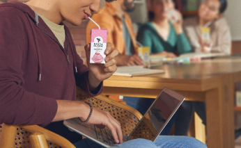 A person drinking milk from a carton