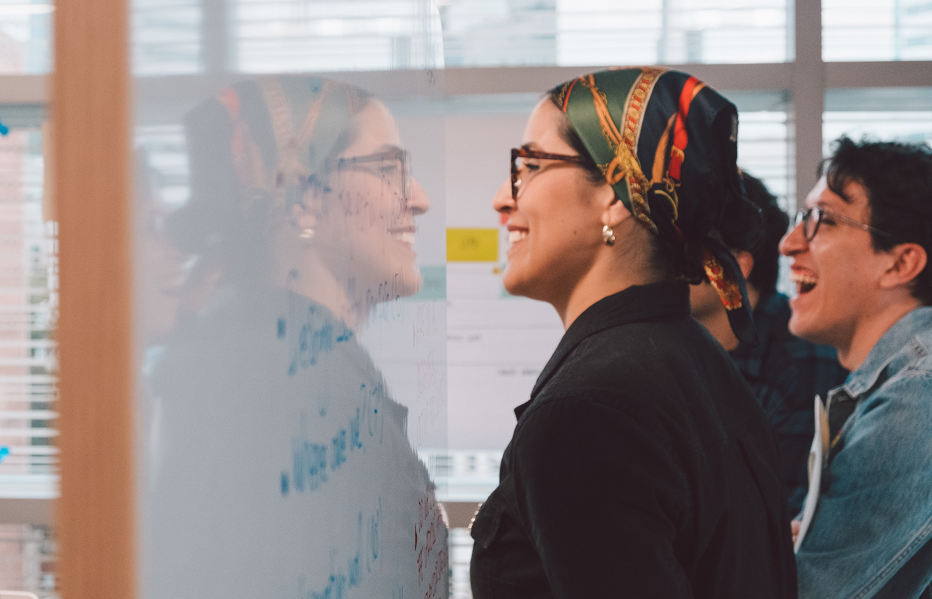 Two tech employees review a dry board workspace together