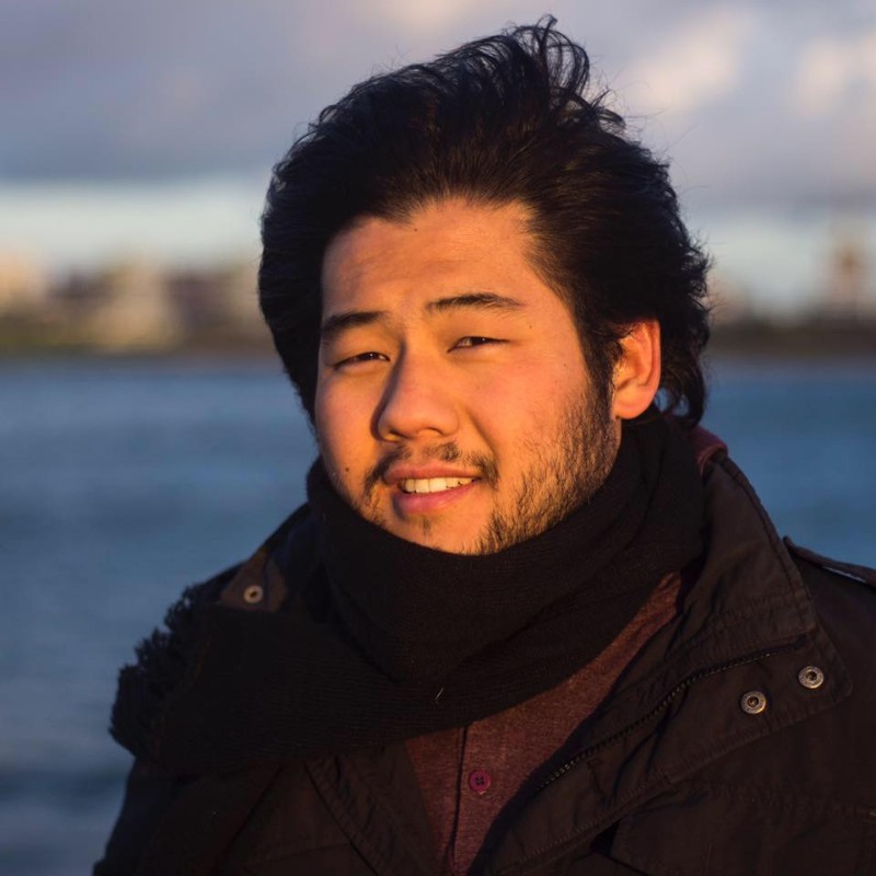 portrait of man in a scarf against a lake background