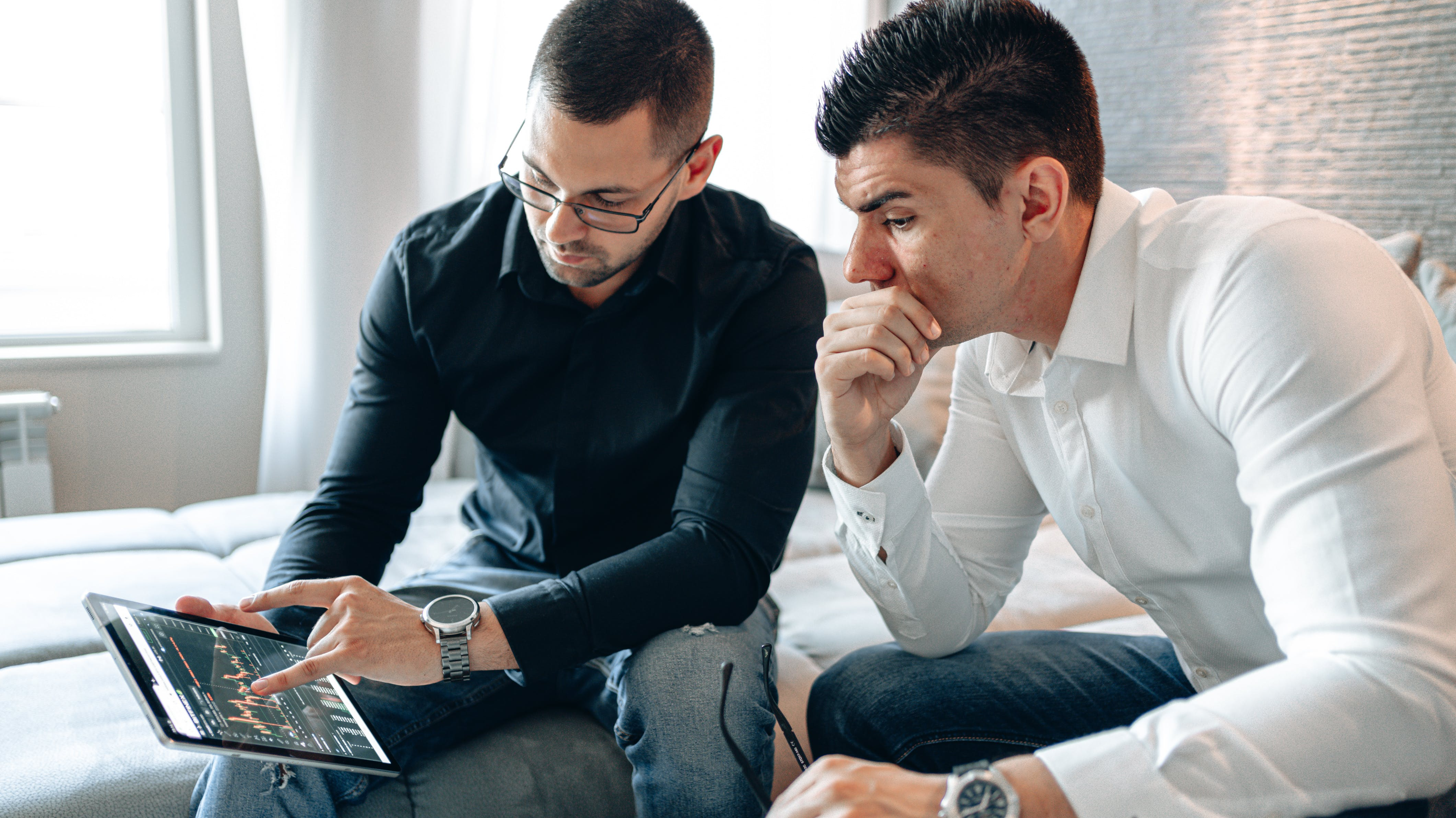 Two men talking over a tablet at work