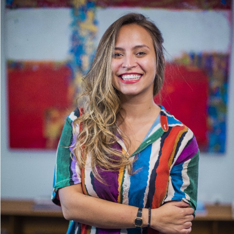 Gabriela Maia, with blonde hair and a colorful shirt