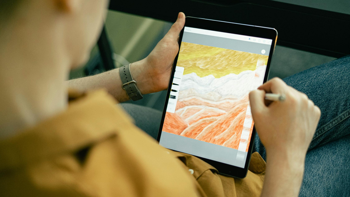 A person using adobe illustrator on a tablet