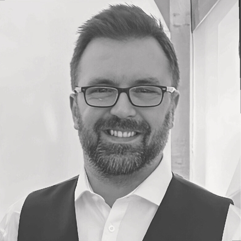 headshot, picture of man wearing vest with beard and short hair