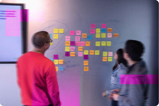People working together around a large amount of post it notes on a wall