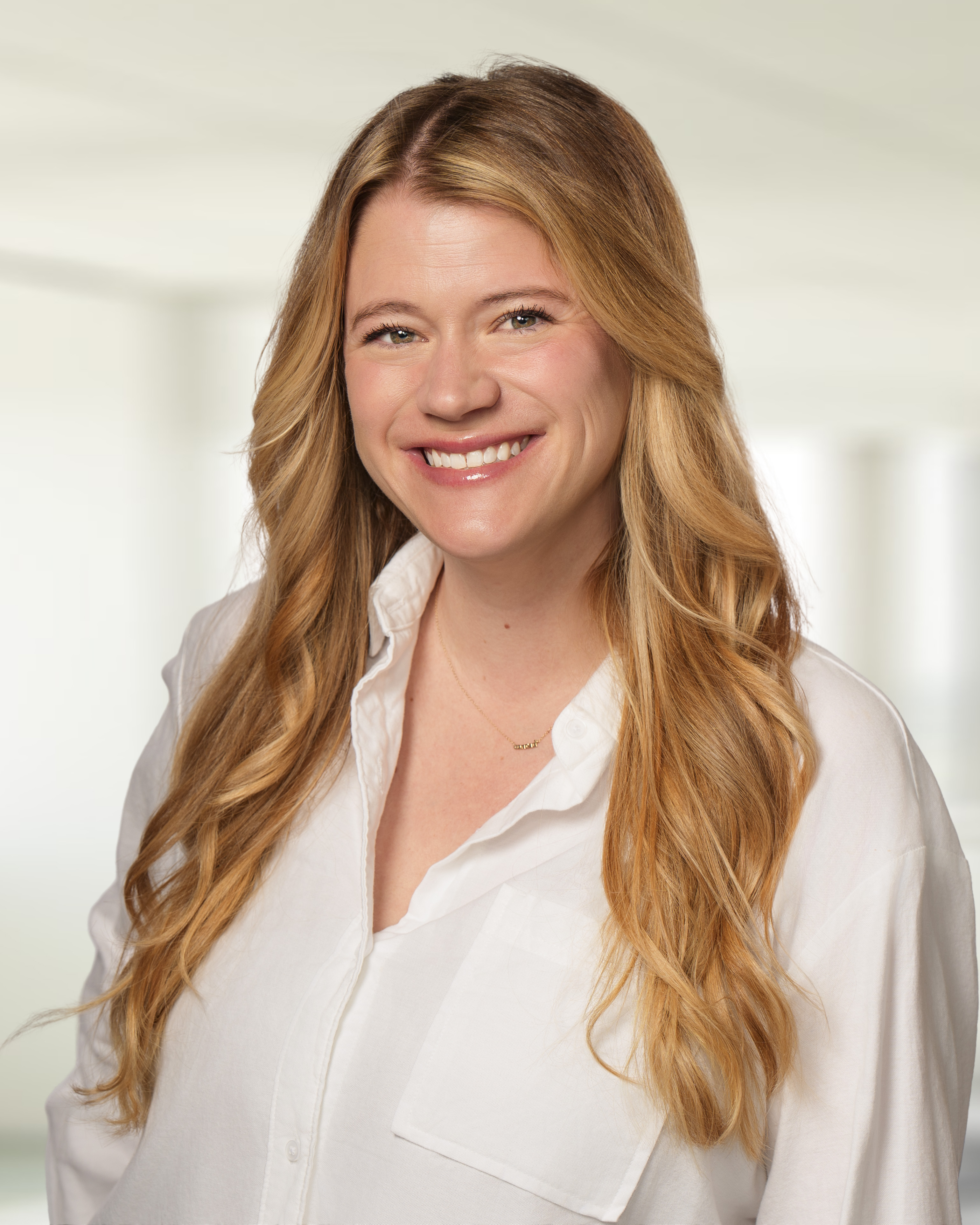 Maddy Cross, Director of Marketing at Paylocity, smiling at the camera in a white office building