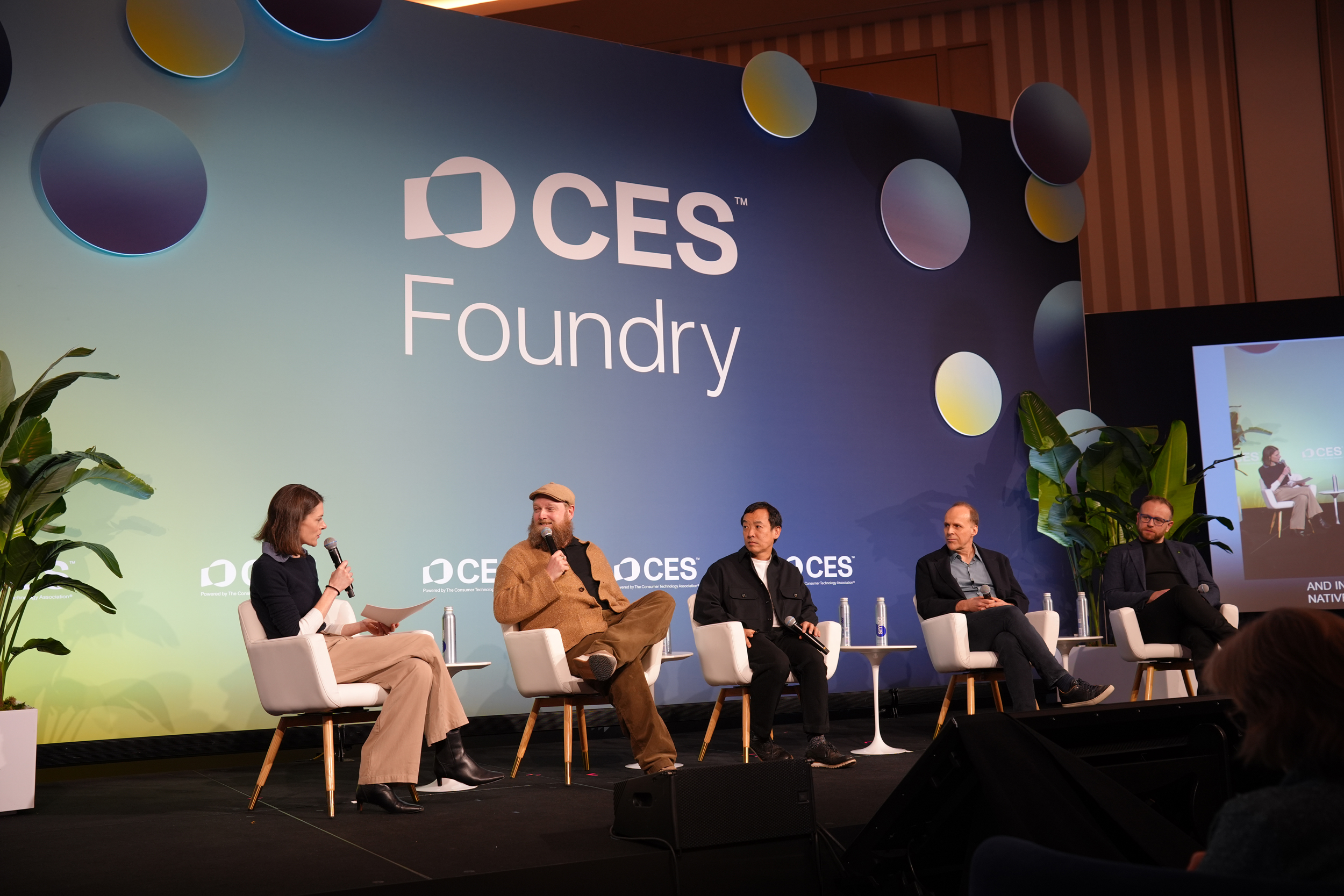 a panel of people on a stage with a sign that reads "CES"