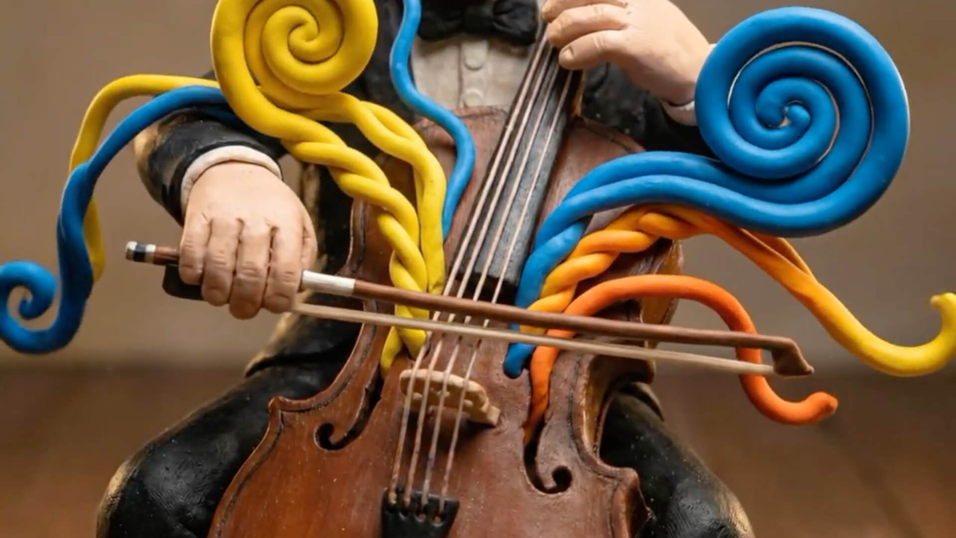 AI-generated image of a claymation person playing cello while colorful swirls emerge from the instrument
