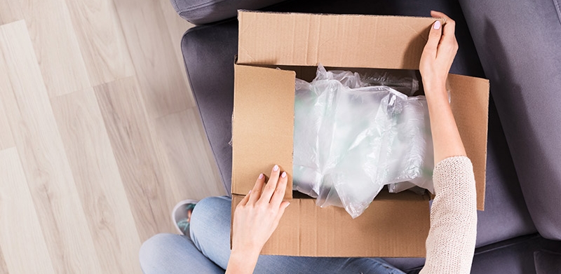 Woman's hands opening delivery box