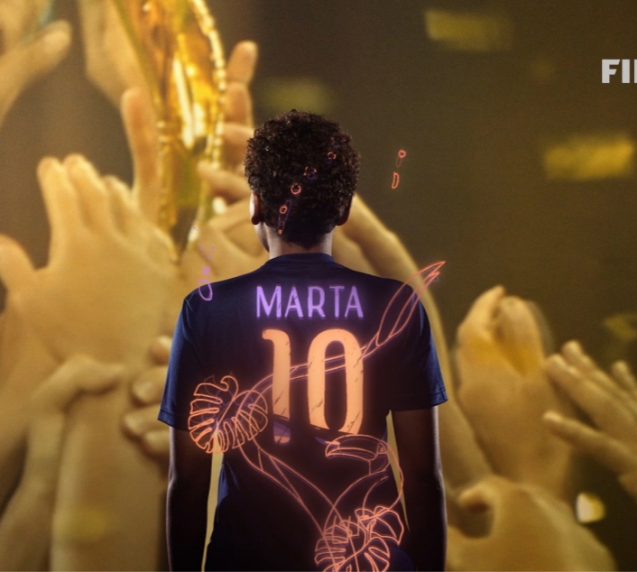 Soccer player stands with arms raised in the air