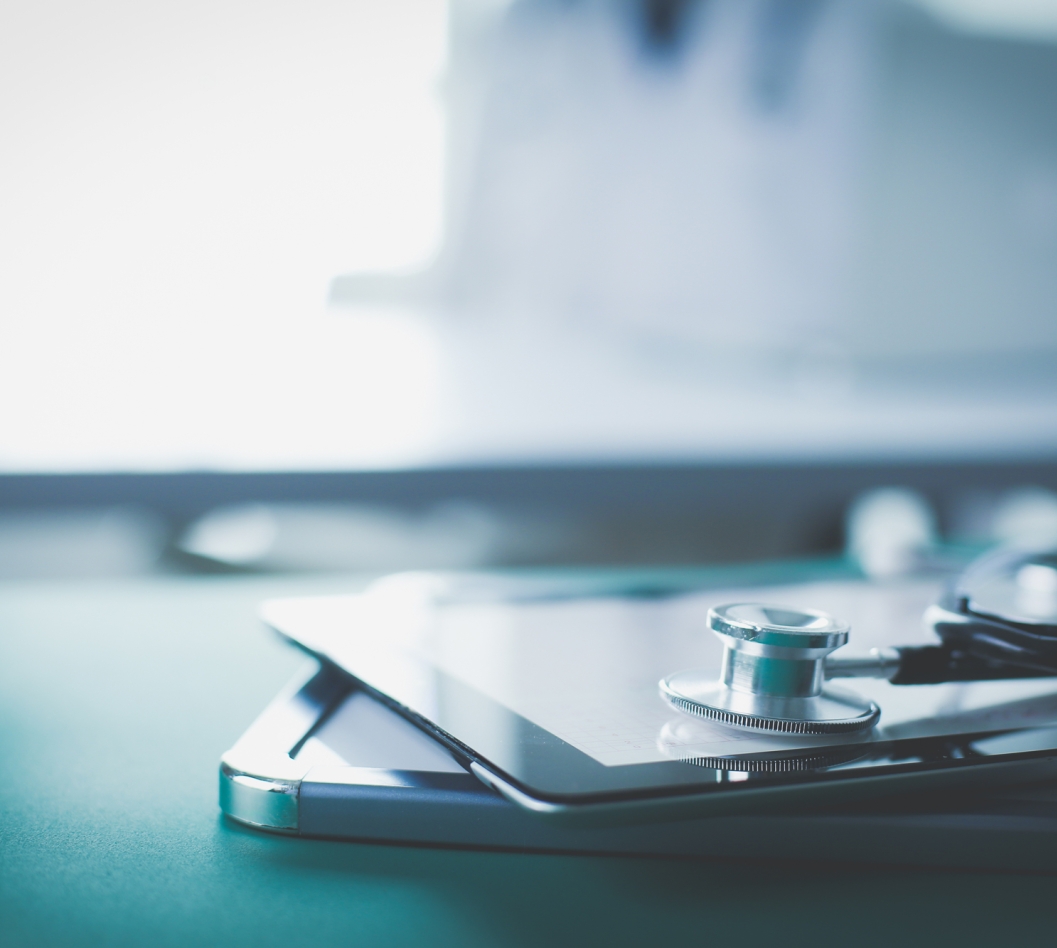 A stethoscope sits on top of a doctors notebook 