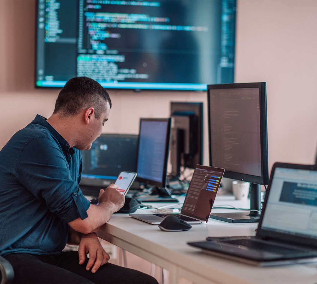 A person working at a desk with a bunch of computer equipment