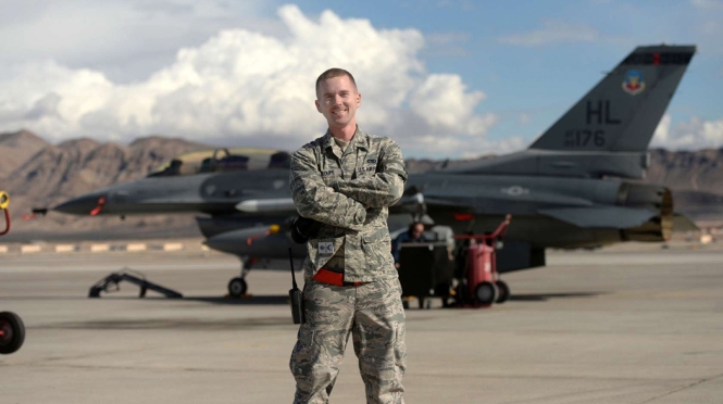 A person in the Airforce standing in front of a plane