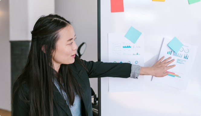 A person working at a whiteboard with sticky notes