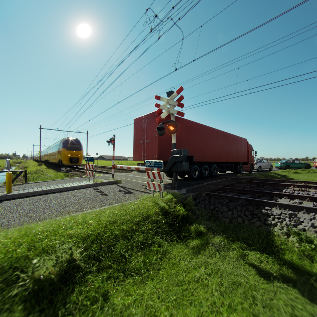 Situation of a dutch railway transition. A train is arriving but a truck did not clear the track yet.