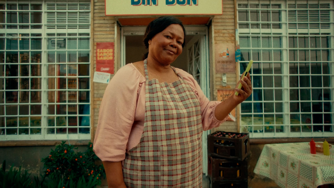 A woman holding a phone standing in front of a store