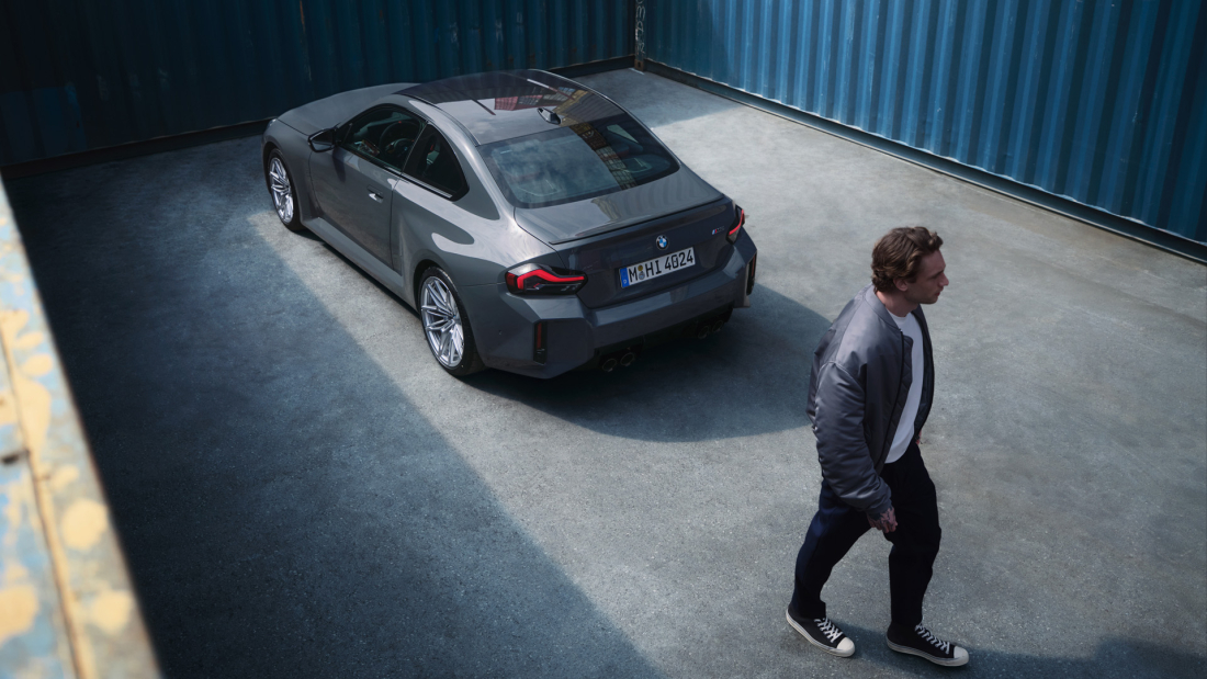 A person standing outside of a bmw
