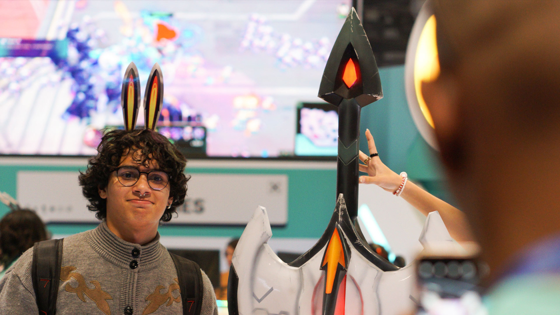 A person with small anime ears in his hair is posing with the League of Legend blade.