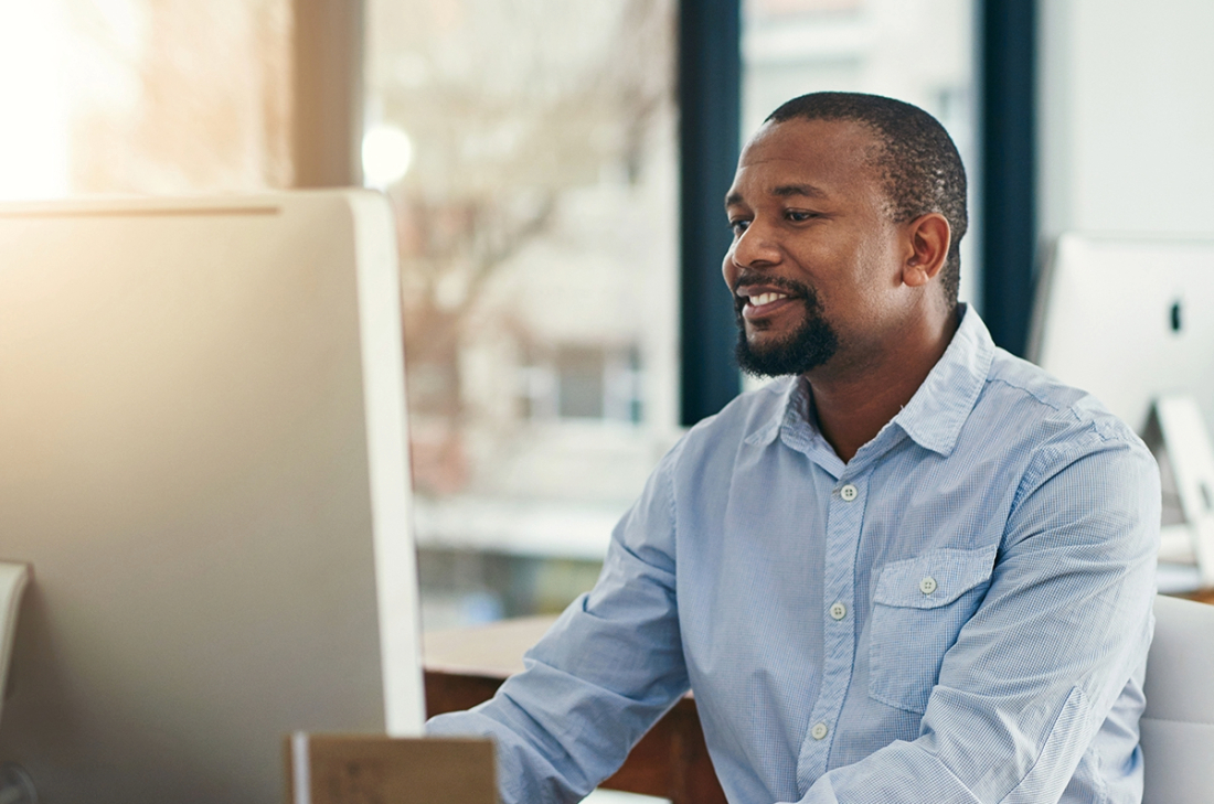 A man in an office working on a computer.