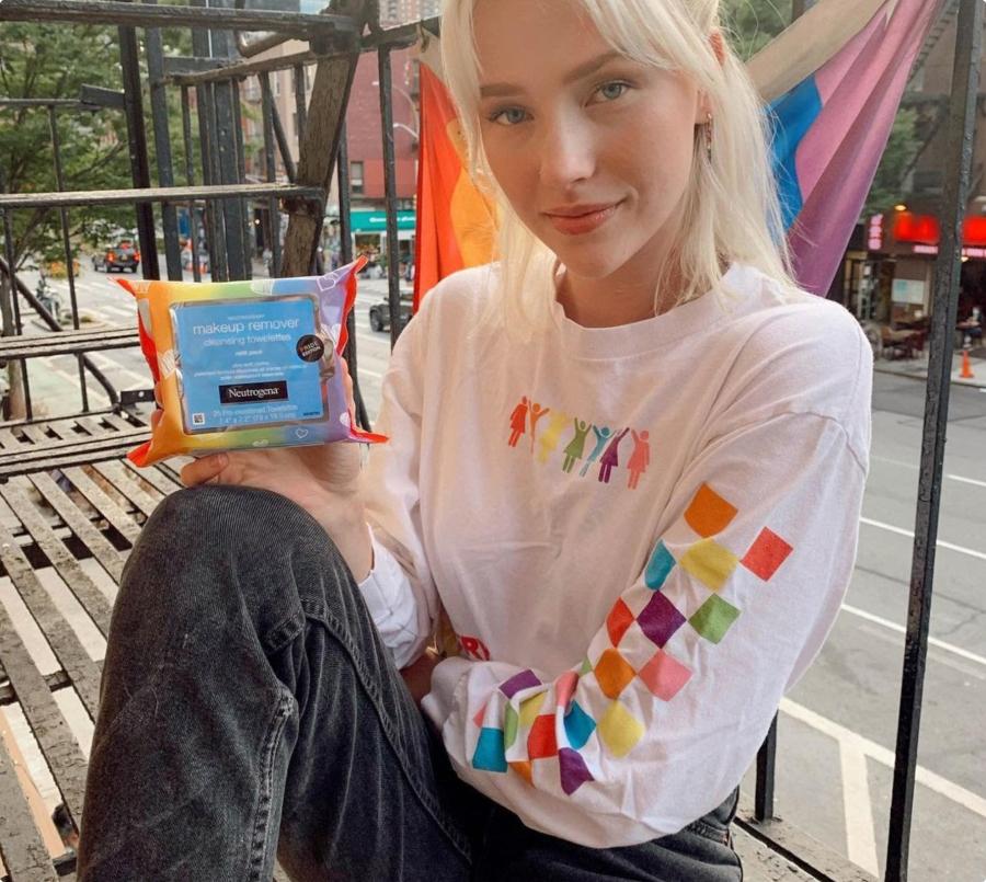 A person holding a package of make up remover wipes