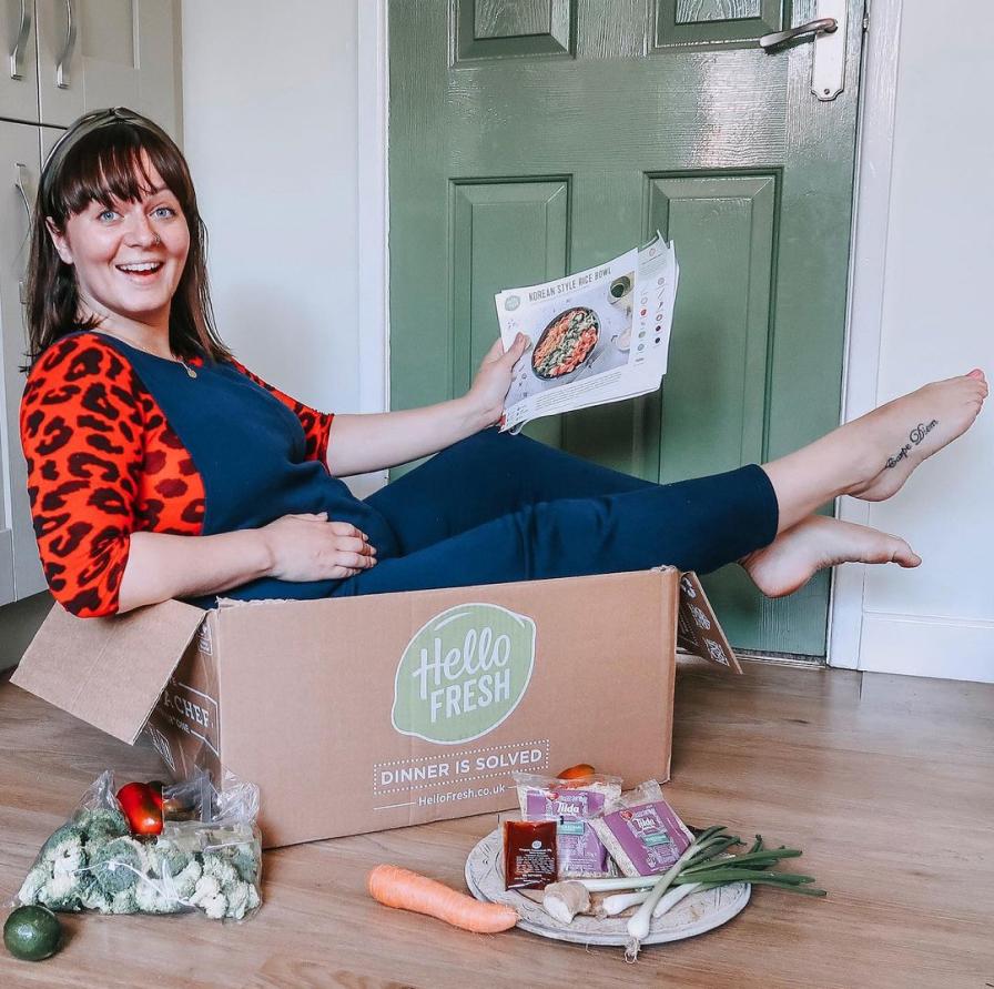 Woman sitting in Hello Fresh box