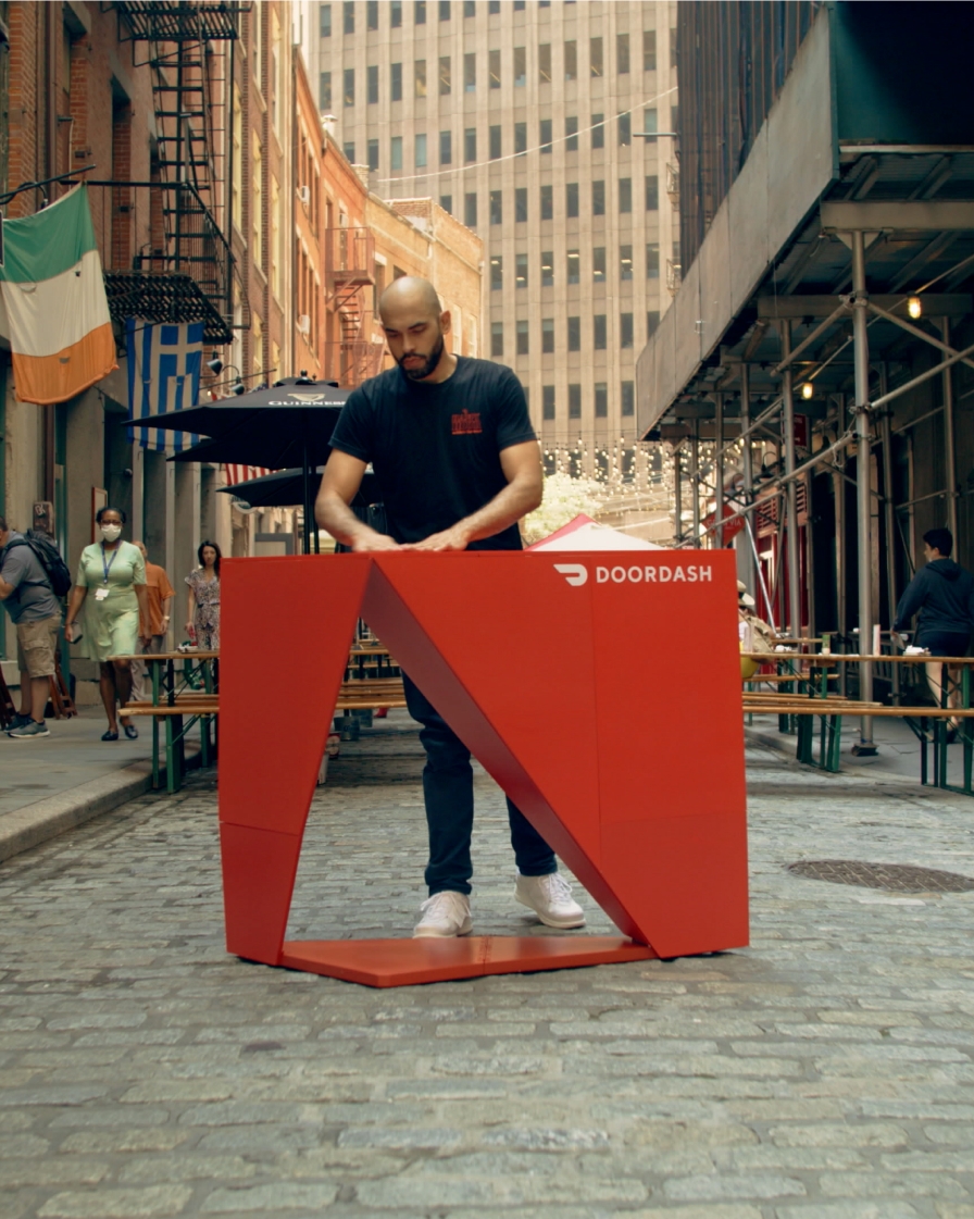Delivery person setting up a bar on a cobblestone street in new york city