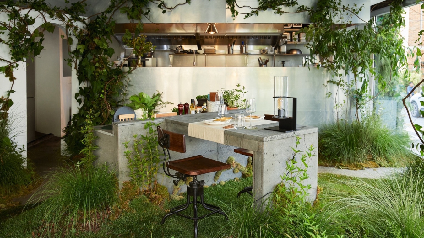 A desk in a restaurant overgrown by plants