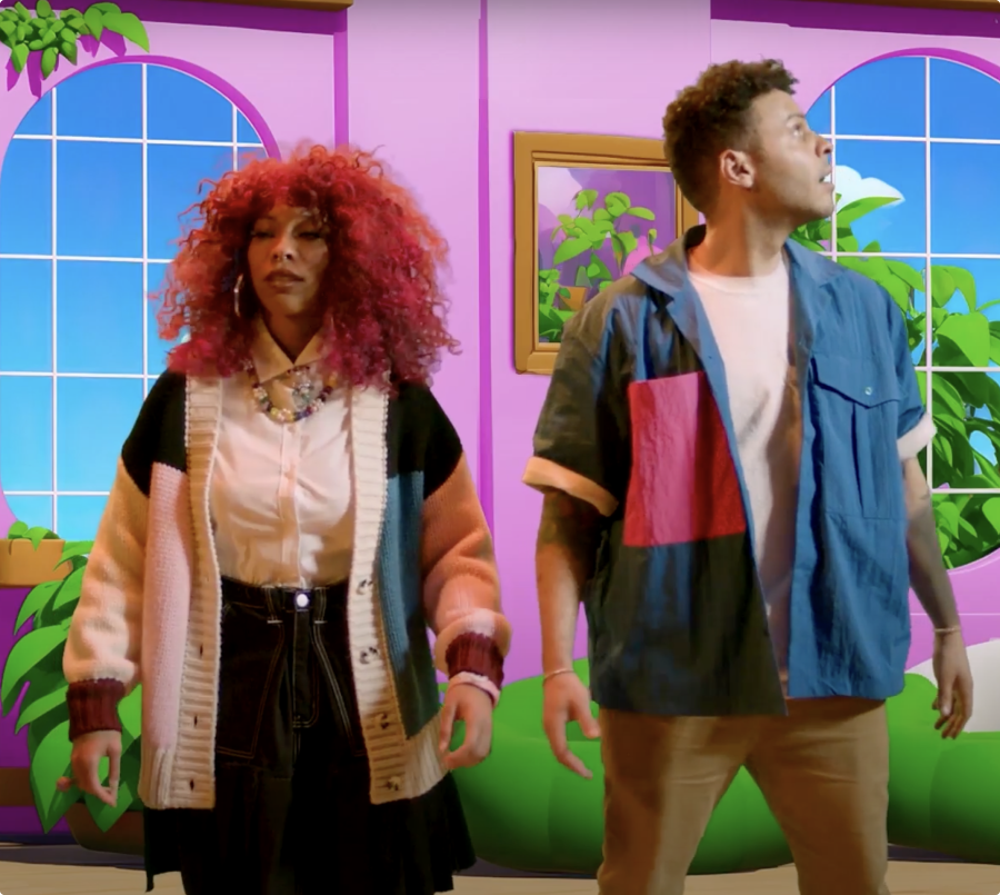 Man and woman standing next to each other. in the background you see a colourful illustrated living room setting.