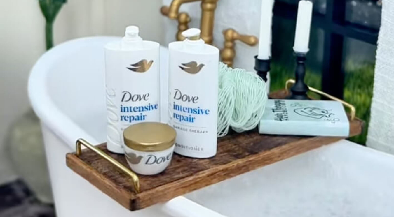 Dove Hair products sitting on a small table over a bathtub in a pretty bathroom setting.