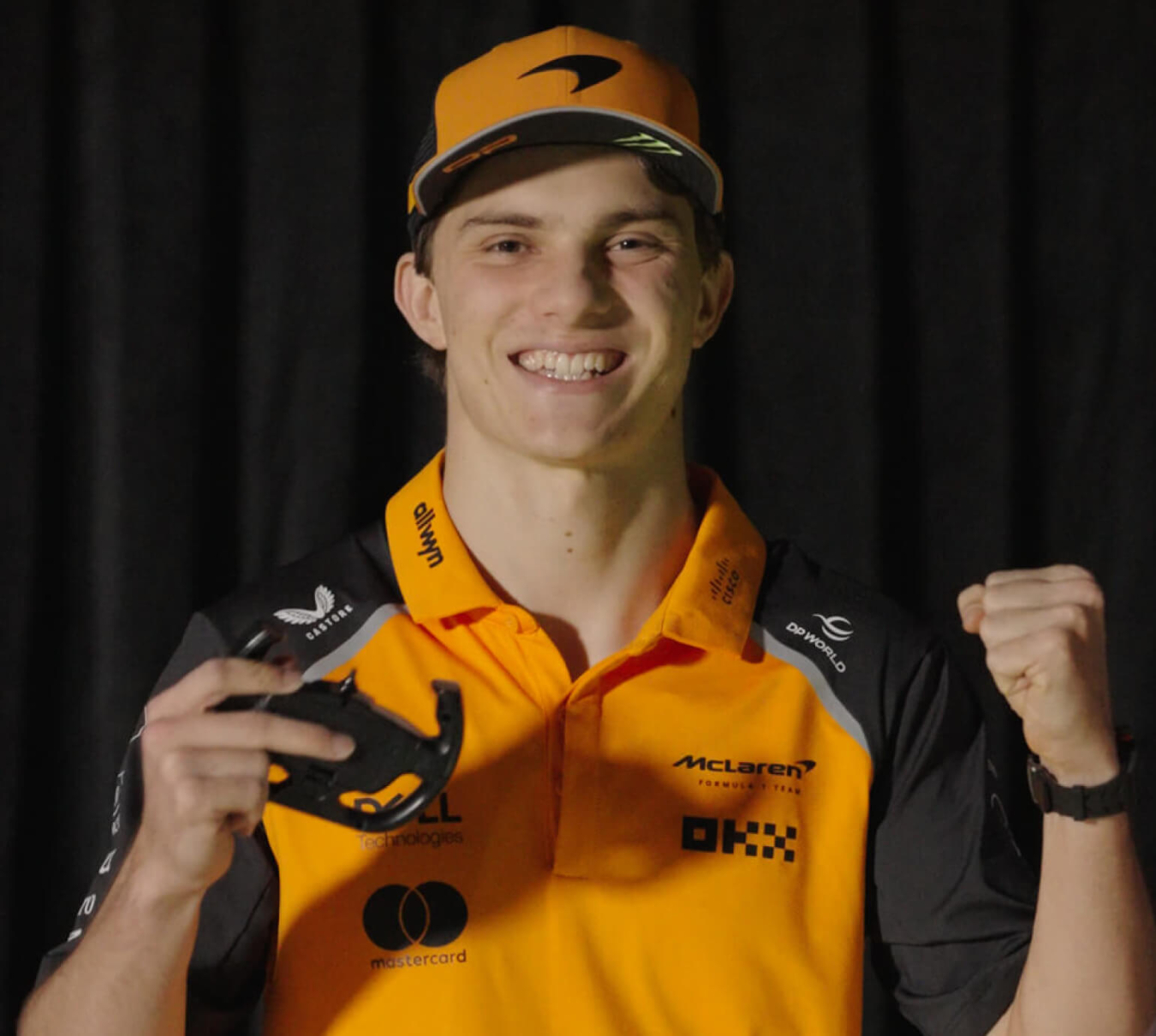 Oscar Piastri F1 driver holding an RC car controller smiling
