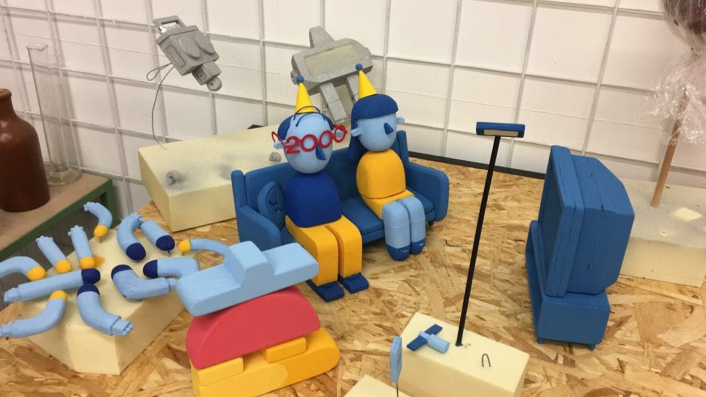 Setting of a frame that will be animated. Two puppets sitting on a coach looking at a blue tv.