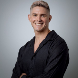 Tyler Stewart in front of a gray background