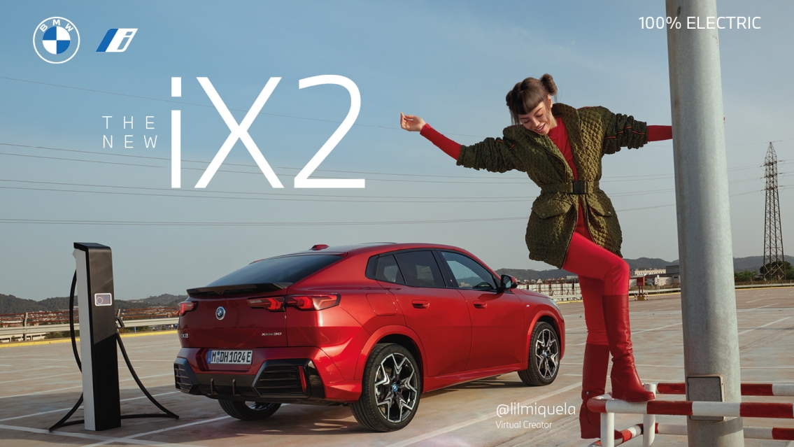 BMW The new iX2 car in red seen from the side. In front of the car you see Lil Miquela dressed in a red pants. She stands on a pole.